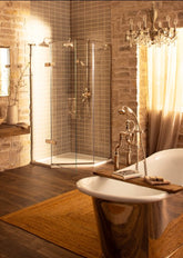Luxurious bathroom with a freestanding bathtub, shower enclosure, and chandelier.