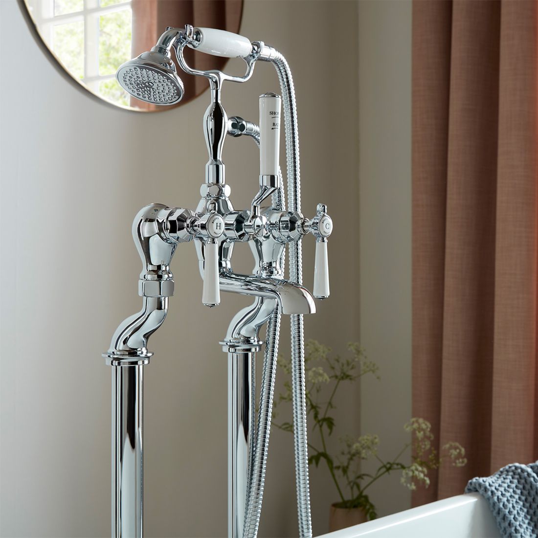 Chrome bathtub faucet with handheld shower head in a bathroom setting